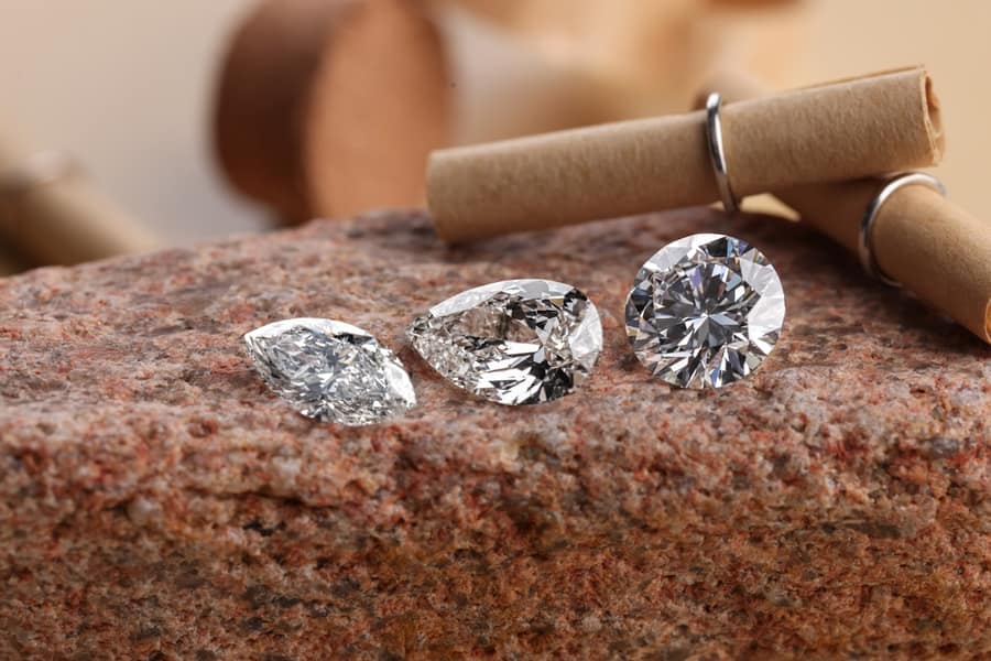 Marquise, pear and round brilliant diamonds standing loose on a granite slab